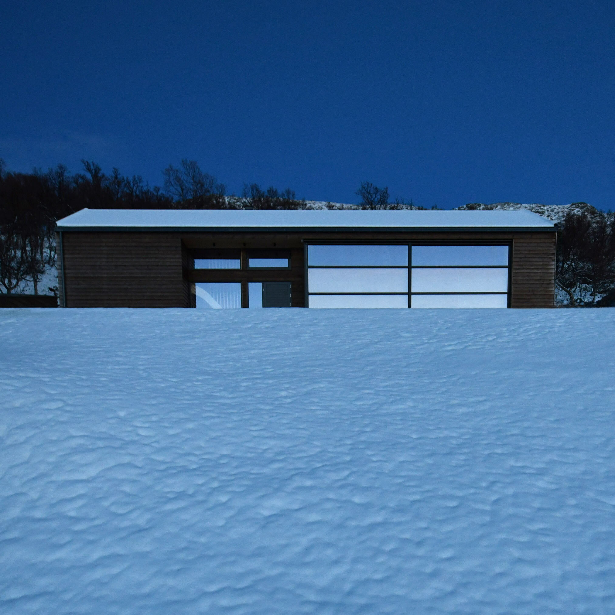 Arkitekttegnet hytte vinterhytte vinterfjellet vinterferie hyttetur kveldsstemning blaa time solnedgang arkitektur